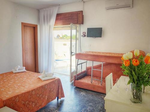 a bedroom with a bed and a table with a vase of flowers at Hotel Pineta in San Menaio