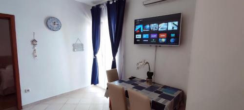 a room with a table and a tv on a wall at Apartments Burazer in Šibenik