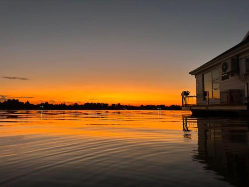 a sunset over a body of water with a dock at House of Bell - Vaal River in Vanderbijlpark