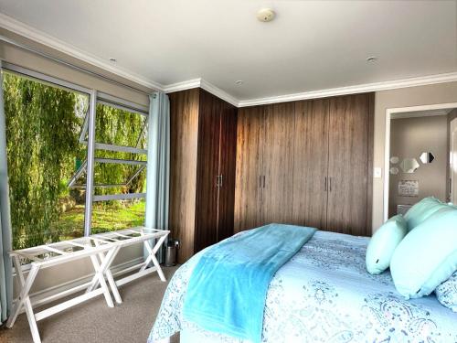 1 dormitorio con cama y ventana grande en House of Bell - Vaal River, en Vanderbijlpark