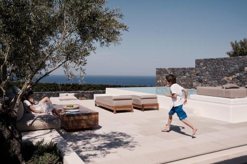 a man is running on the patio of a house at Canaves Epitome - Small Luxury Hotels of the World in Oia