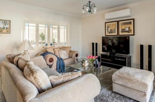 a living room with a couch and a tv at Cosy private room easy access to city & airport in Melbourne