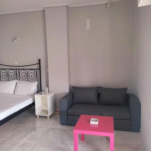 a living room with a couch and a pink table at Sky Loft in Loutraki