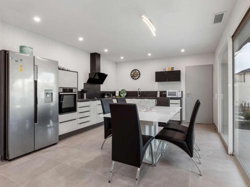 une cuisine avec une table, des chaises et un réfrigérateur dans l'établissement Villa T4 climatisée avec jardin, jacuzzi et Free WiFi à 600 m de la plage - FR-1-423-234, au Cap d'Agde