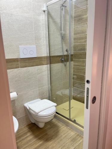 a bathroom with a toilet and a glass shower at Ù BBI PÓ in Casal Sottano
