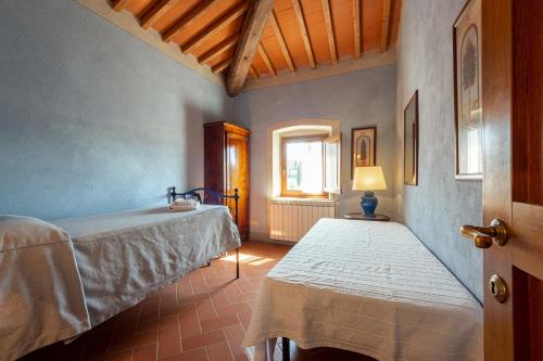 a bedroom with two beds and a window at Agriturismo I Bonsi in Reggello