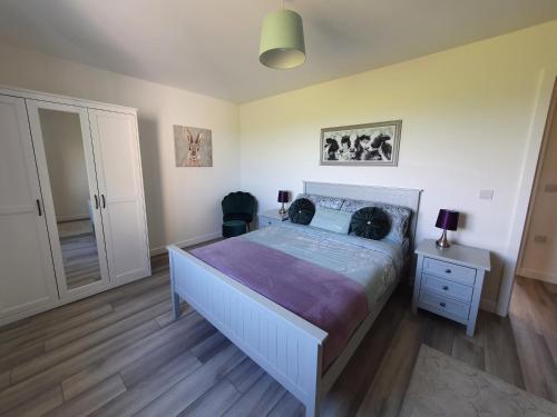 ein Schlafzimmer mit einem Bett mit einer lila Bettdecke in der Unterkunft Redland Cottage in Orkney