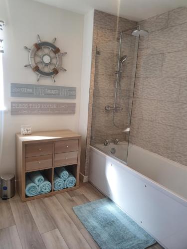 a bathroom with a bath tub and a shower at Redland Cottage in Orkney