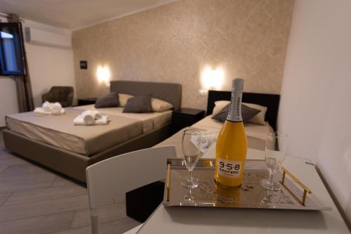 una habitación con una botella de vino en una mesa con copas en Bed and Breakfast Horizon, en Tropea
