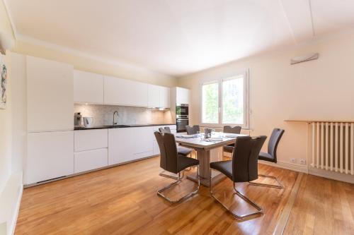 une cuisine et une salle à manger avec une table et des chaises dans l'établissement L'Amédée - Appt à 500m du lac, à Annecy