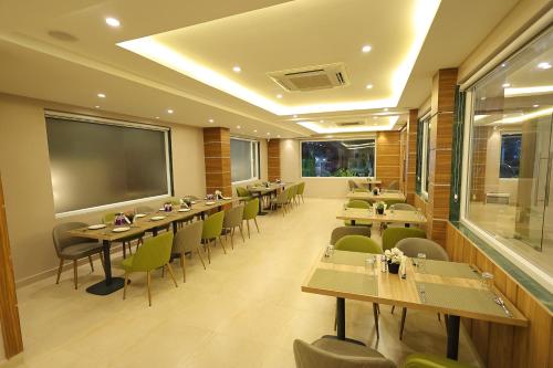 a restaurant with tables and chairs and a large screen at Hotel Sharda Residency in Patna