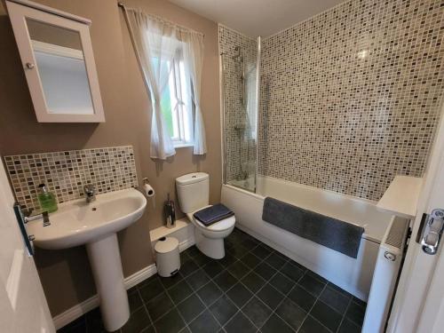 a bathroom with a sink and a toilet and a tub at Kensington House- The Perfect home for contractor stays in Colchester