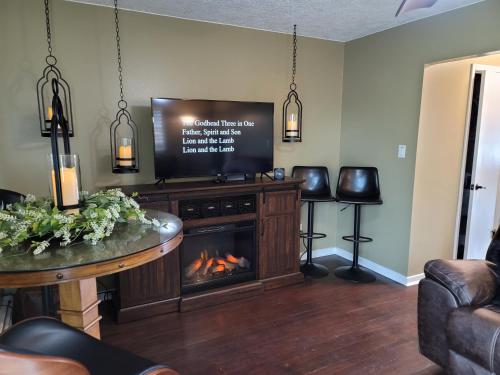 sala de estar con chimenea y TV de pantalla plana en Mountain View Lodging Cody, en Cody