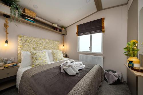 um quarto com uma cama grande e toalhas em Stonewood Premium - 2 bedroom VS04 em Tenby