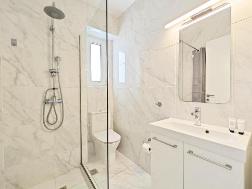 a bathroom with a shower and a toilet and a sink at Nemeseos Apartments by Verde in Athens