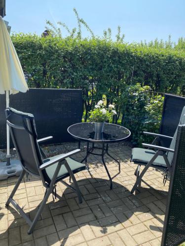 a patio with a table and two chairs and an umbrella at Liten ”stuga” in Falkenberg