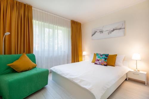 Un dormitorio con una cama y una silla verde. en Sovata Studio, en Oradea