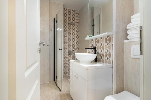 Un baño blanco con inodoro y lavabo. en Sovata Studio, en Oradea