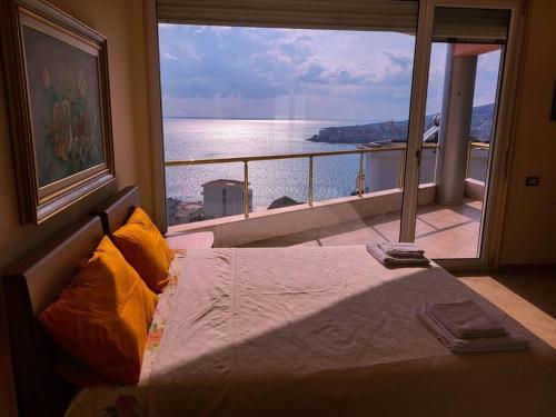 1 dormitorio con vistas al océano desde una ventana en Saranda’s Sky Line Apartment, en Sarandë