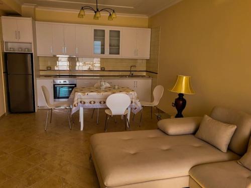sala de estar con mesa y sillas y cocina en Saranda’s Sky Line Apartment, en Sarandë