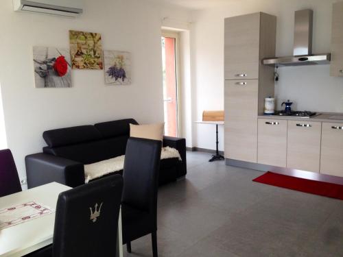 a living room with a black couch and a kitchen at A Lago in Marone