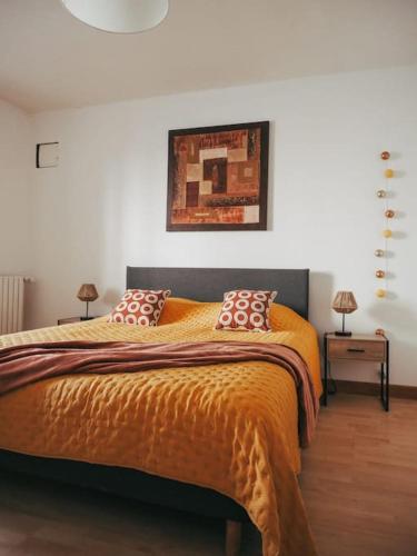 une chambre avec un lit avec une couverture orange dans l'établissement Appartement avec patio, à Sainte-Anne-d'Auray