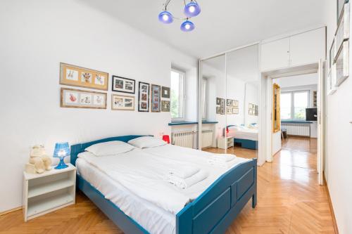 a bedroom with a blue and white bed and a mirror at Białobrzeska 22 by Homeprime in Warsaw