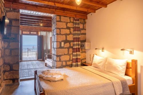 a bedroom with a bed with a view of the ocean at XENIA HOTEL in Sfakia