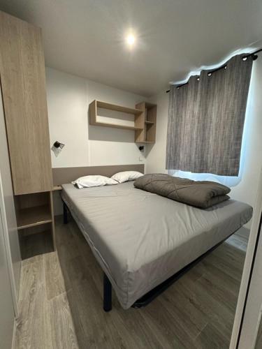 une chambre avec un grand lit avec une fenêtre dans l'établissement Mobil-home, à Lit-et-Mixe