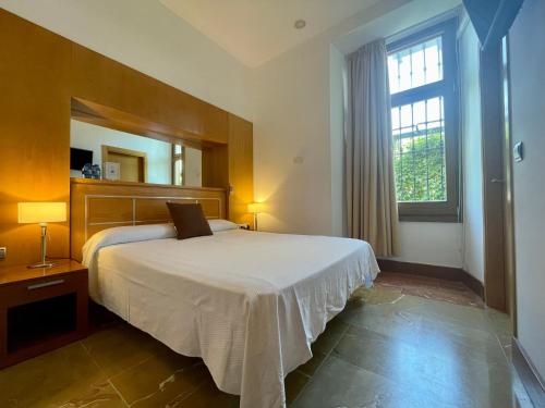 ein Schlafzimmer mit einem Bett und einem großen Fenster in der Unterkunft Acinipo in Ronda