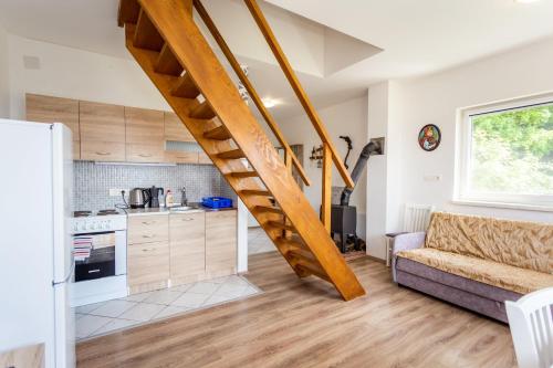 a kitchen and a living room with a spiral staircase at Apartmani Cerovečki in Krapina