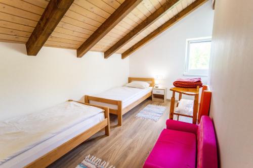 a room with two beds and a chair in it at Apartmani Cerovečki in Krapina