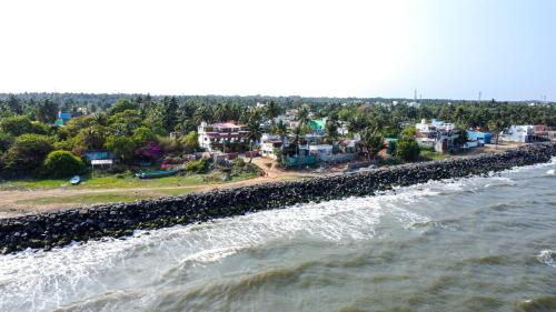 a group of houses on the shore of the water at Mermaid Island Beach Resorts in Puducherry