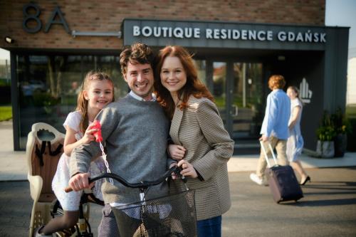 a man and a woman with a girl on a bike at Boutique Residence Gdańsk in Gdańsk