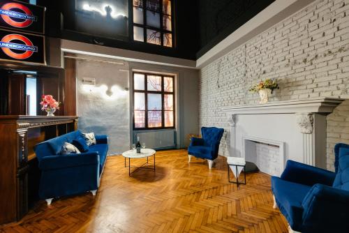 a living room with blue chairs and a fireplace at Palace Bulevard Inn in Cluj-Napoca