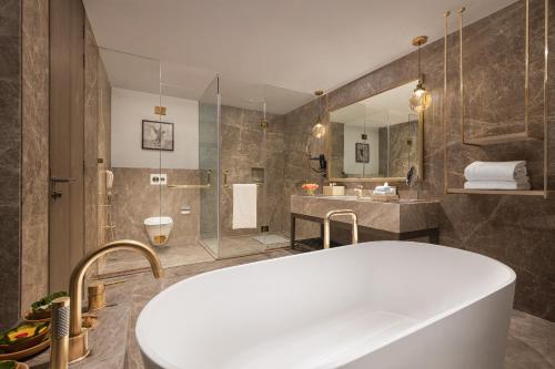 a bathroom with a large tub and a shower at Taj Corbett Resort and Spa Uttarakhand in Rāmnagar