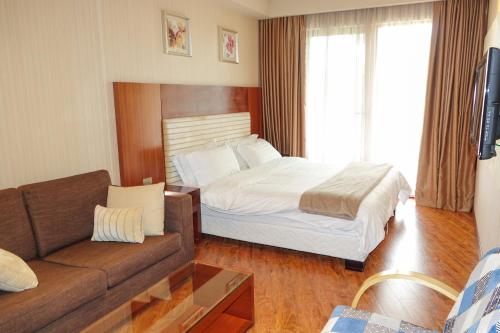 a hotel room with a bed and a couch at Luxury Dreamland Oasis Apartments in Chakvi