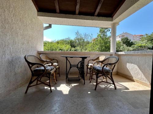 a patio with a table and chairs on a balcony at Apartments Mestrovic, Klimno, Soline bay, island Krk in Klimno