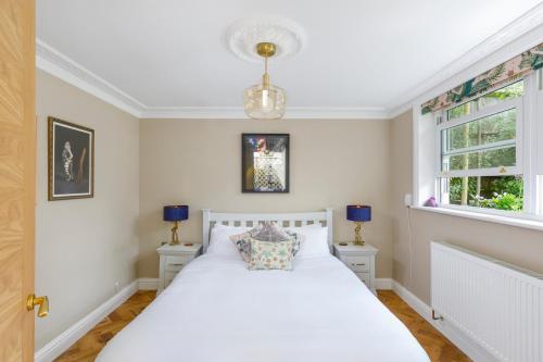 a bedroom with a white bed and two windows at Luxurious Brighton Apartment with Hot Tub in Brighton & Hove