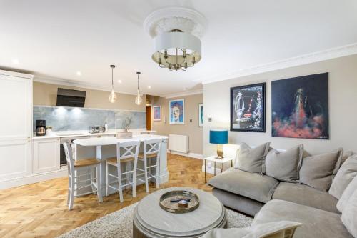 a living room with a couch and a kitchen at Luxurious Brighton Apartment with Hot Tub in Brighton & Hove