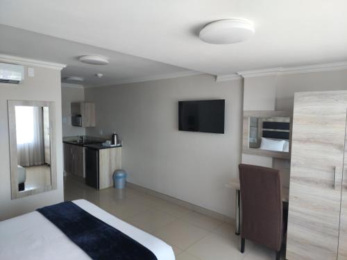 謝普斯敦港的住宿－Bayside Taj Hotel，酒店客房设有一张床和墙上的电视