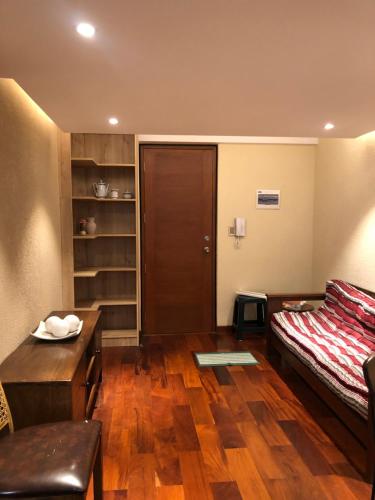Cette chambre comprend un lit, une table et un bureau. dans l'établissement Apartamento acogedor en Achumani, à La Paz