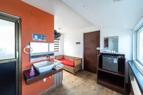 a bathroom with a sink and a red wall at Mermaid Island Beach Resorts in Puducherry