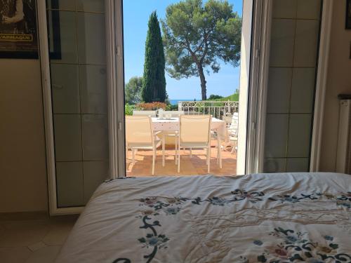- une chambre avec un lit et une vue sur une terrasse dans l'établissement Villa Rima, bas de villa vue mer avec piscine à 200m des plages, à La Ciotat