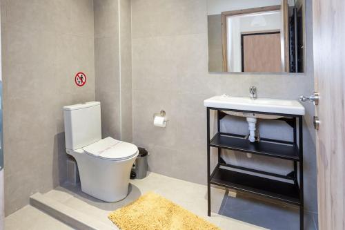 a bathroom with a white toilet and a sink at Elegant Apartment in Thessaloniki