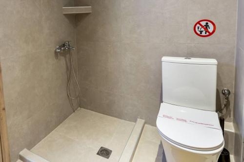 a bathroom with a toilet with a sign on the wall at Elegant Apartment in Thessaloniki