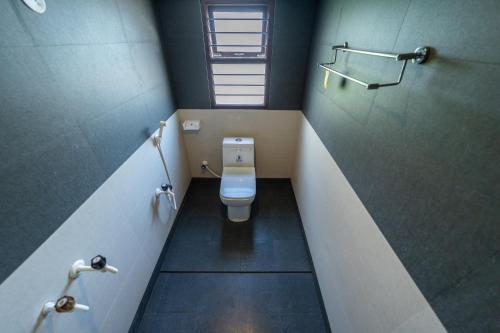 a small bathroom with a toilet in the middle at Mermaid Island Beach Resorts in Puducherry