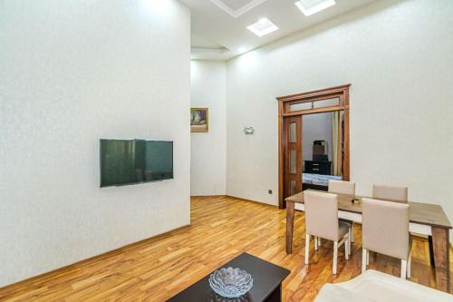 - une salle à manger avec une table, des chaises et une télévision dans l'établissement City centre apartment, à Baku