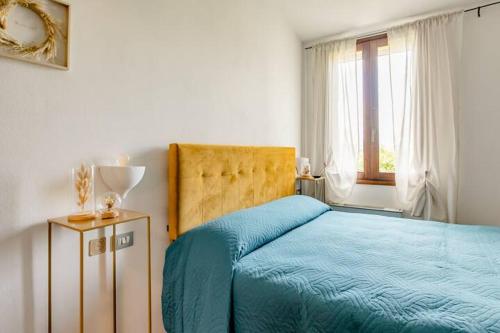 Un dormitorio con una cama azul y una ventana en Locanda delle grotte di Onferno en Gemmano