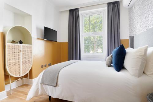 um quarto com uma cama branca e uma janela em Sonder Camden Road em Londres